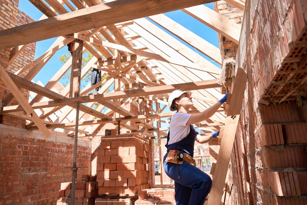 Bauarbeiter im Rohbau mit Dachstuhl aus Holz